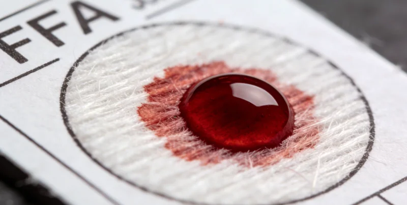 一只手指向一份展开的基因检测报告,旁边摆放着象征亲子关系的温馨家庭合影。